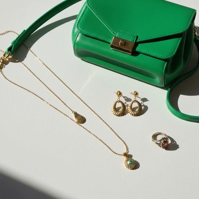 Stylish accessories including a statement bag and vintage jewelry on a neutral background, no text, no words, no typography, clean image